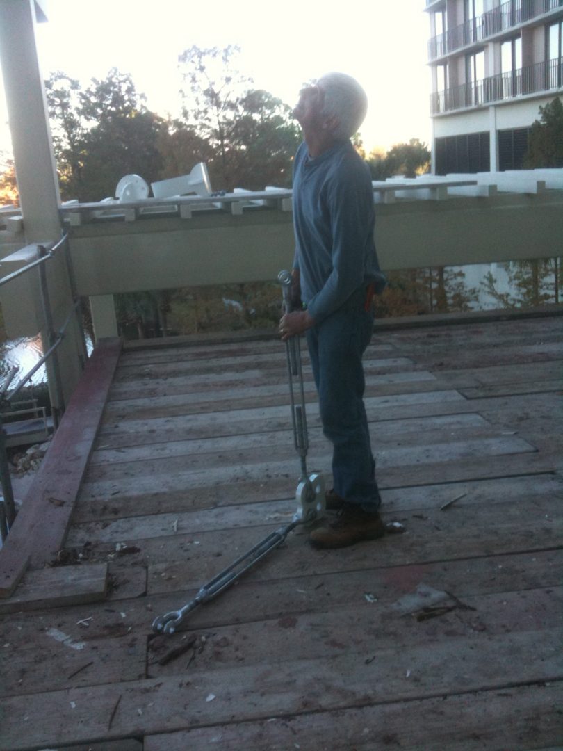 A person stands on a wooden surface holding a scooter.