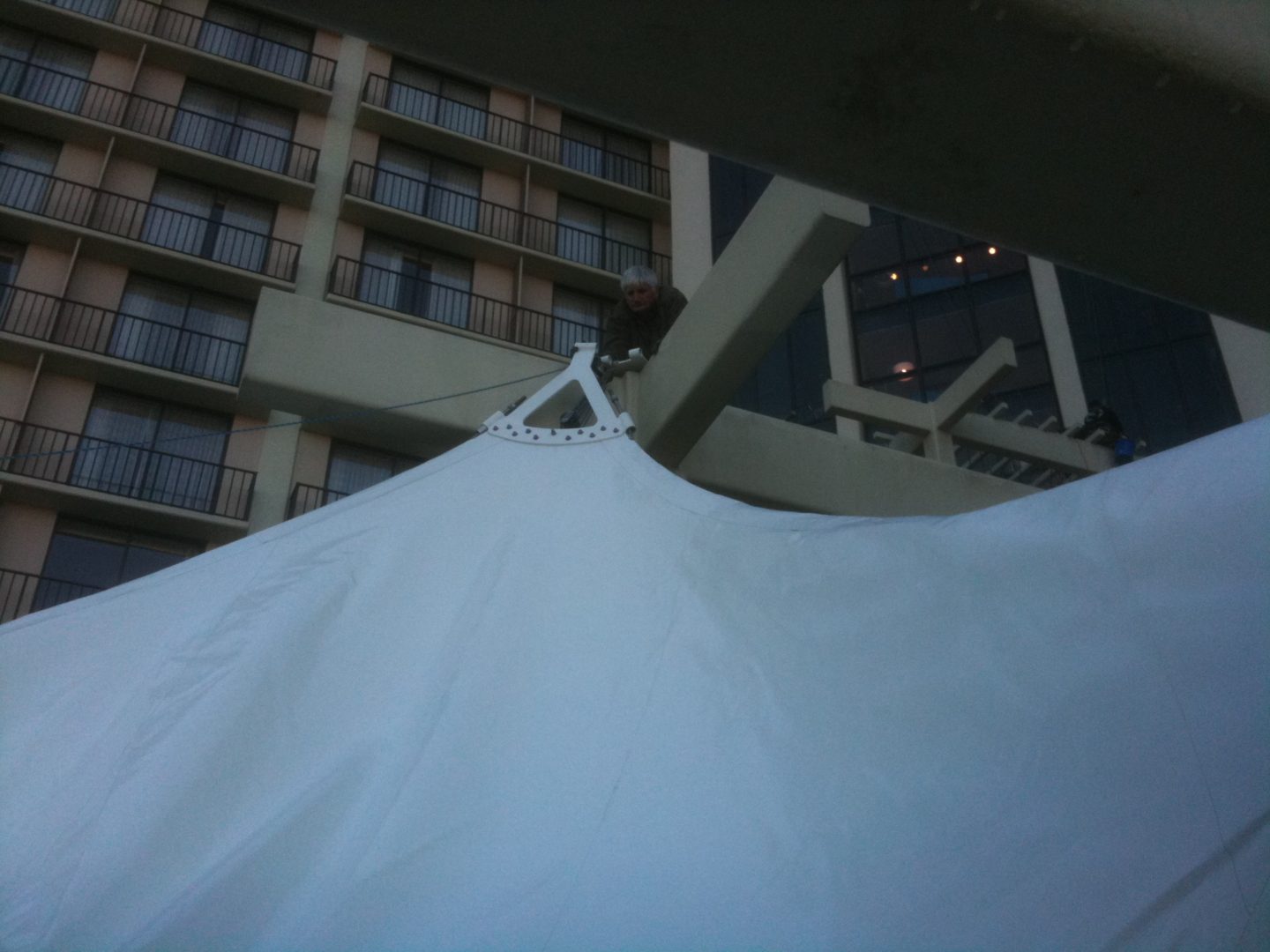 View of a tall building behind a white tent or canopy.