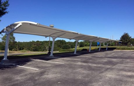 A long covered outdoor walkway under a clear blue sky.