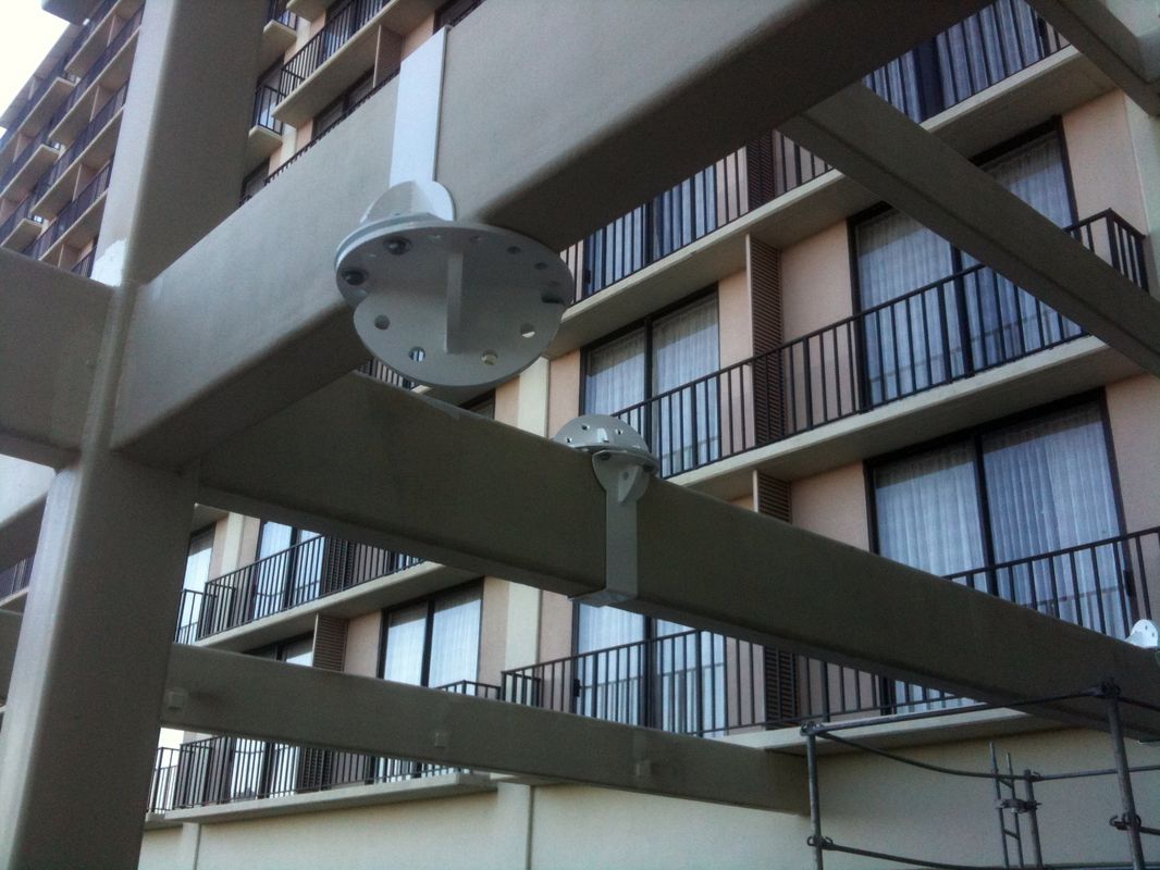 Security camera mounted on an outdoor balcony beam.