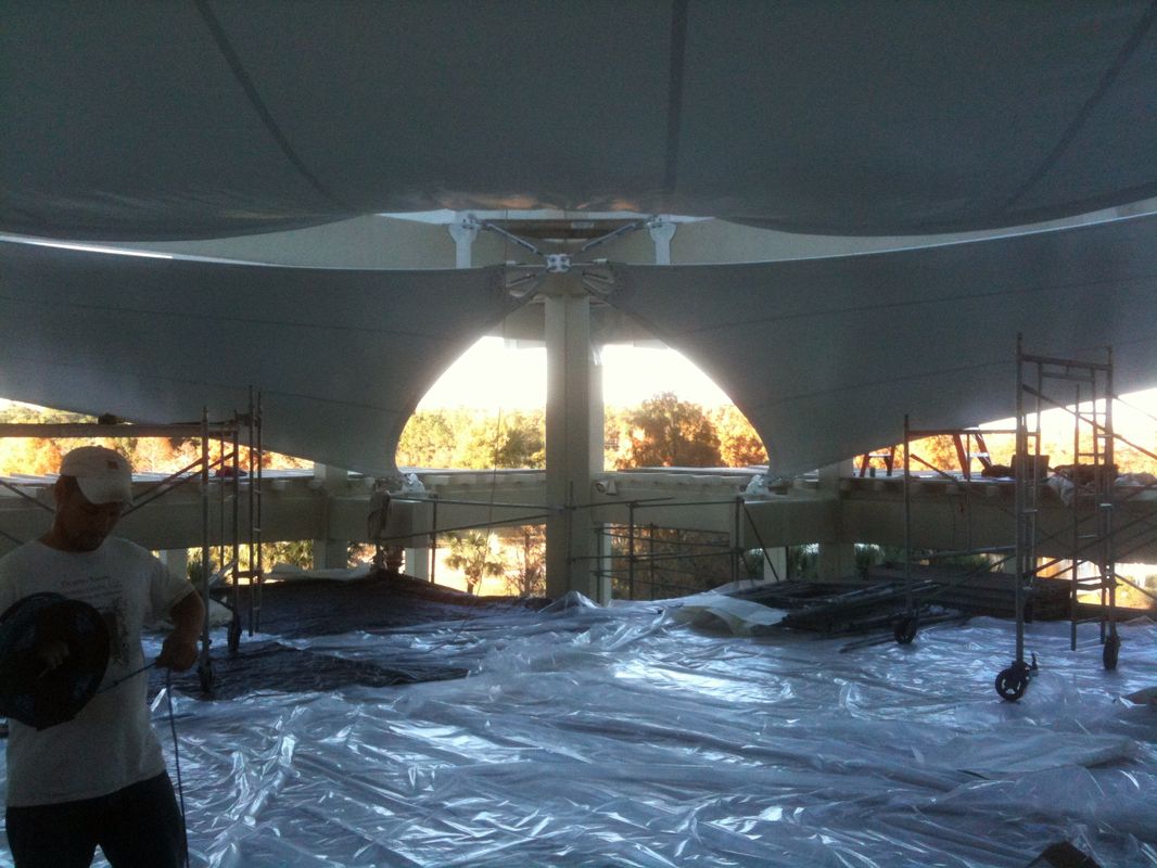 Sunset view through a tent structure over a water body.