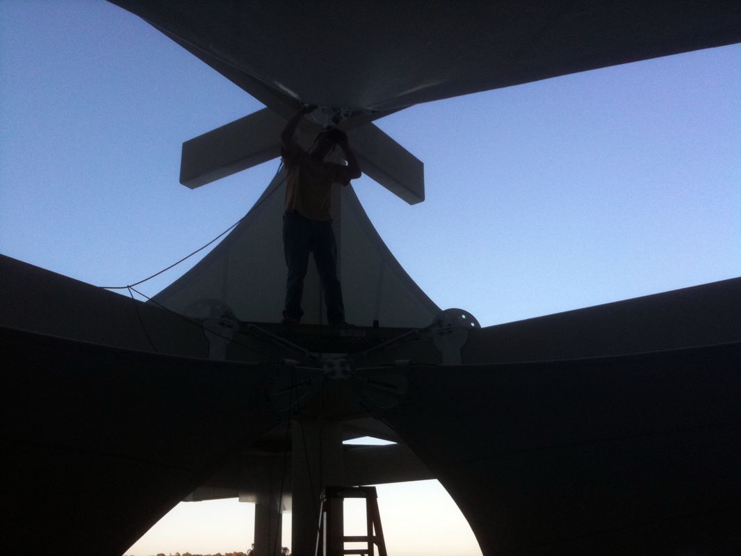 Person standing on a large structure during sunset or sunrise.