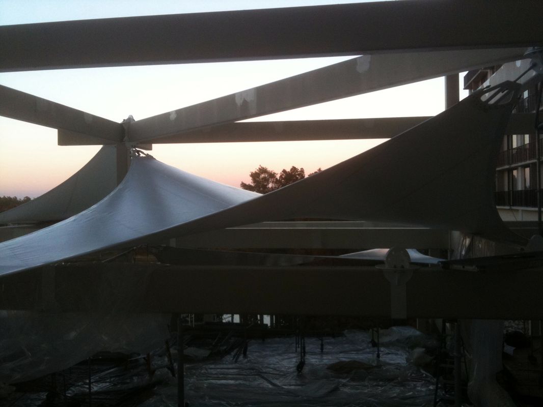 Sunset viewed through overlapping triangular shade sails.
