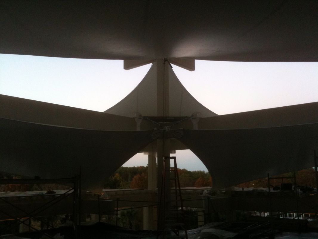 Architectural structure with a triangular roof design against a dim sky.