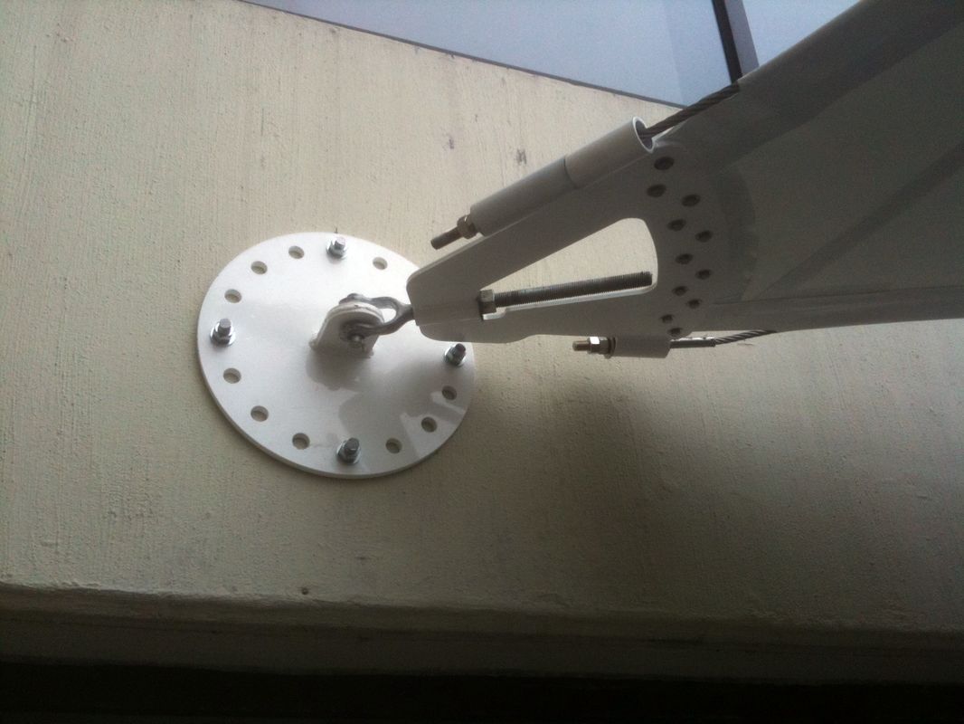 Close-up of a mechanical arm attached to a circular base on a wall.