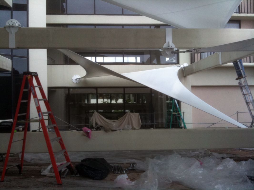 Interior of a building under renovation with ladders and covered furniture.
