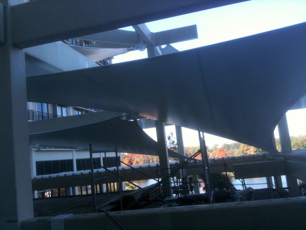 Modern architectural beams and columns with a cityscape in the background.